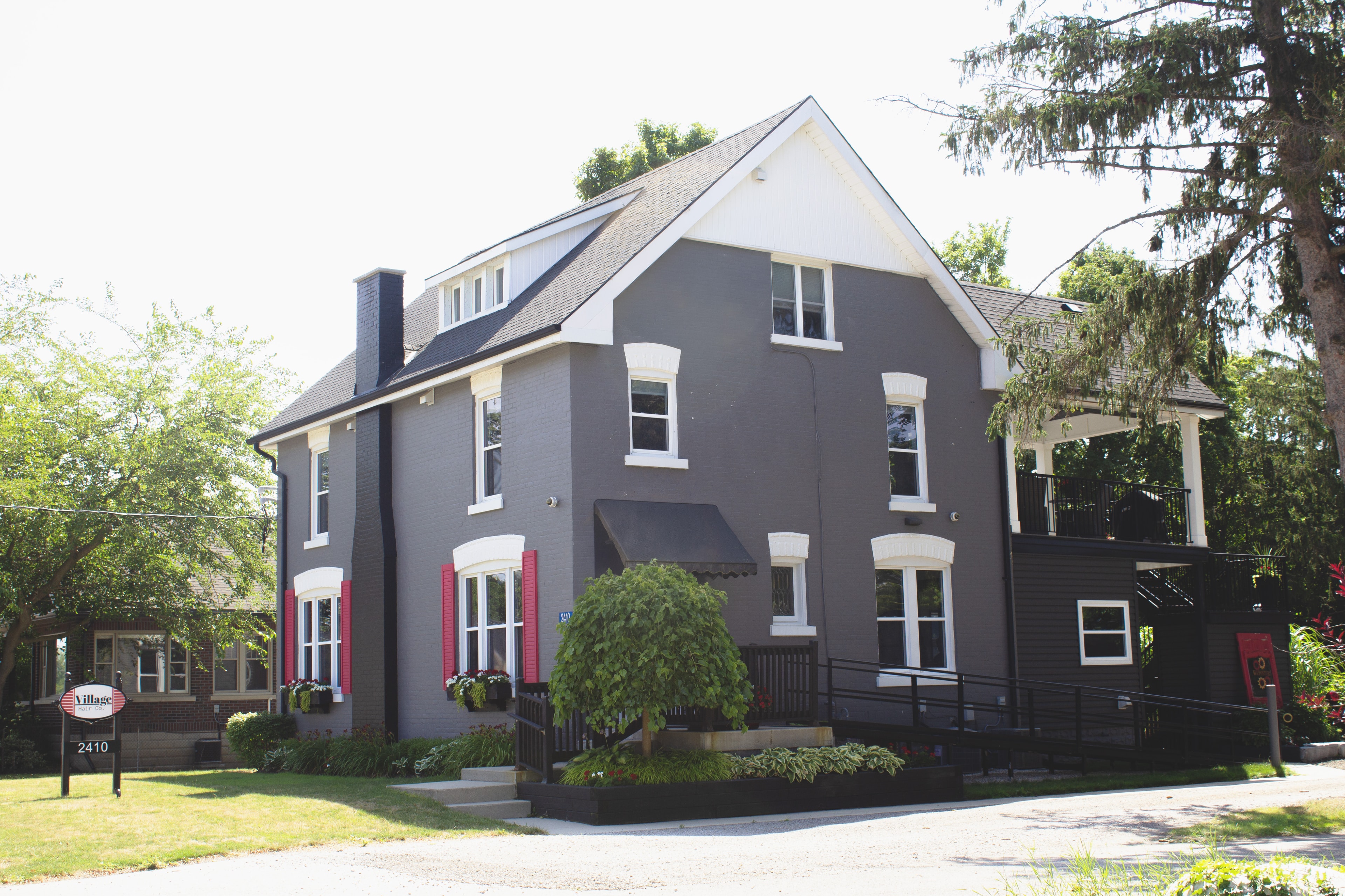 Village Hair Co. charcoal Victorian house exterior with red accents